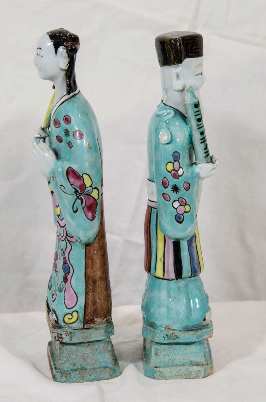 Two of the eight Chinese Immortals. Well known in Chinese folklore the Immortals are thought to know the secrets of nature. This pair are dressed in bright turquoise robes with pink and yellow accents showing butterflies, flowers and fruit.