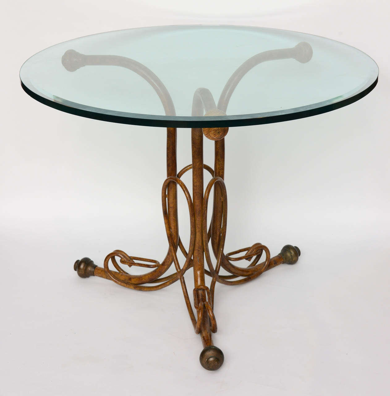 The circular glass top above a metal base painted faux bois, marked Thonet to the underside with label.