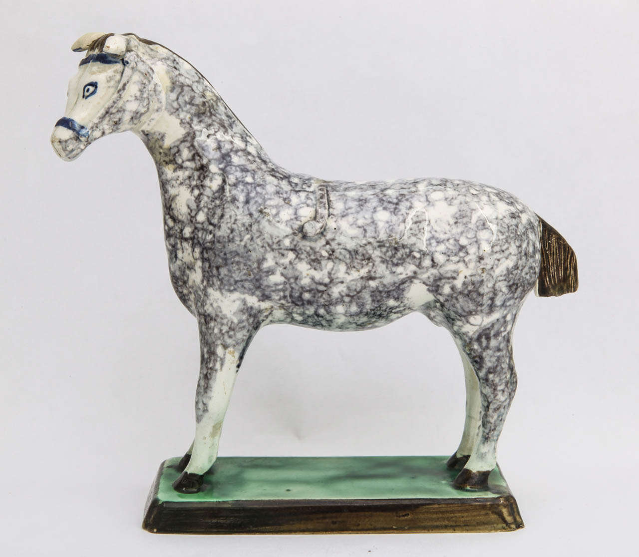 A rare English pearlware pottery (attributed to Saint Anthonys Pottery) figure of a standing horse decorated in underglaze blue, gray, green and brown colors