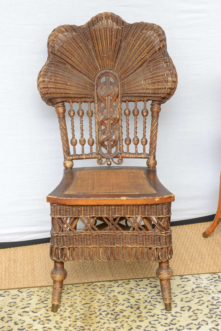 Heywood -Wakefield wicker chair, woven seats, tapered legs,  remnant and rolling brass casters,, wear and scuffs, minor wicker losses and looseness, varnish alligatoring on seats, Estate collection seat height 16.