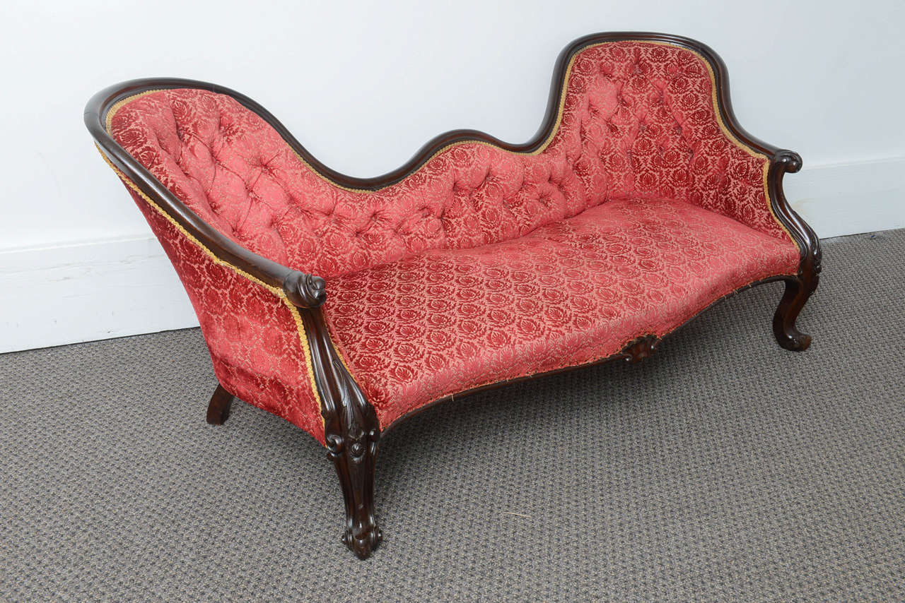 This is a very nice solid mahogany Victorian double ended chaise longue made in England, circa 1880.
The frame is pretty solid and the fabric is also in pretty good condition.
It sits on French style cabriolet legs to either side on the back there