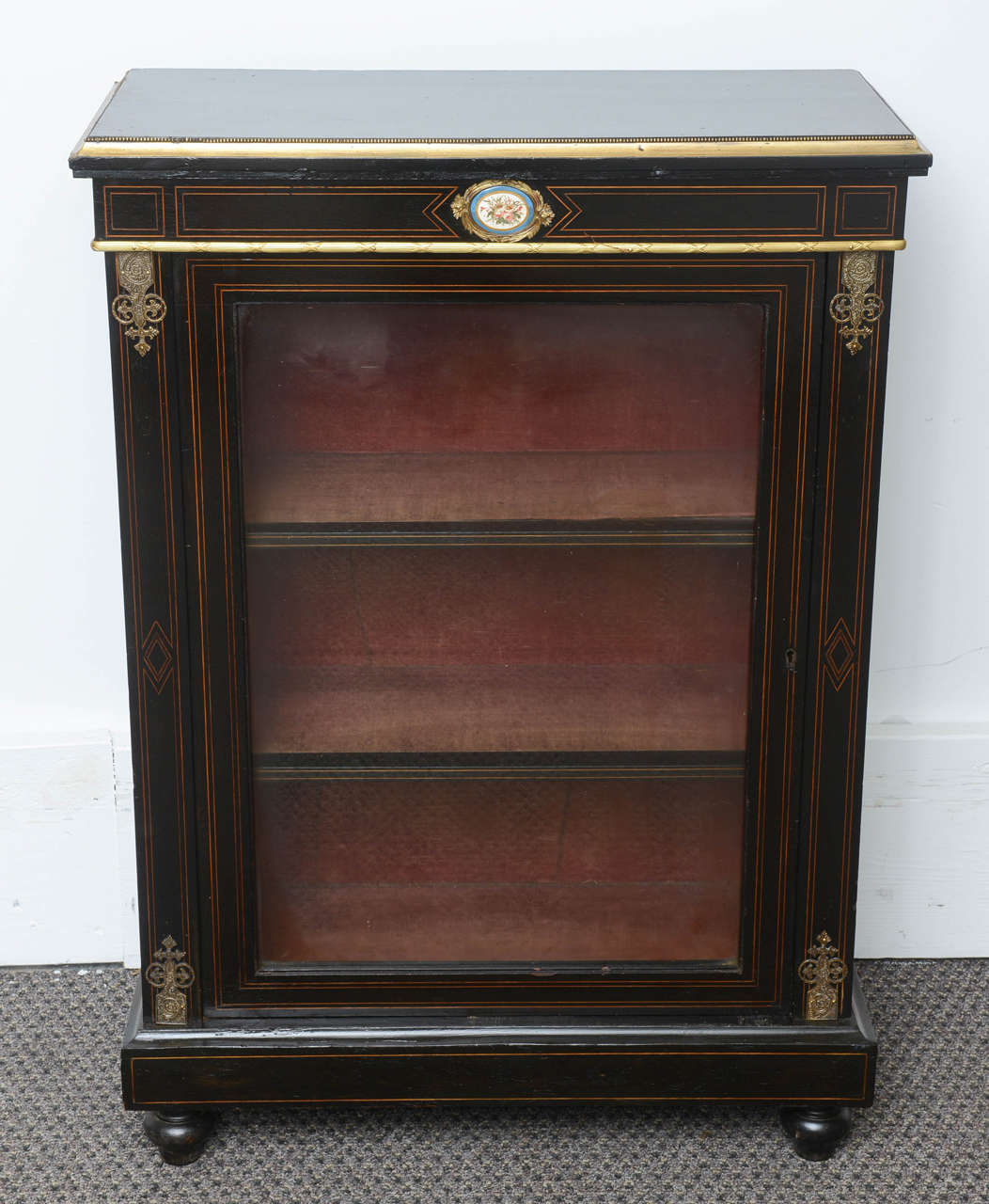 These are a very nice also rare to get a pair of black ebony cabinets with French Limoges plaques to the center top.
To the top they has brass bands round the edges and sides, to the front they also so brass crests to the top and bottom of the