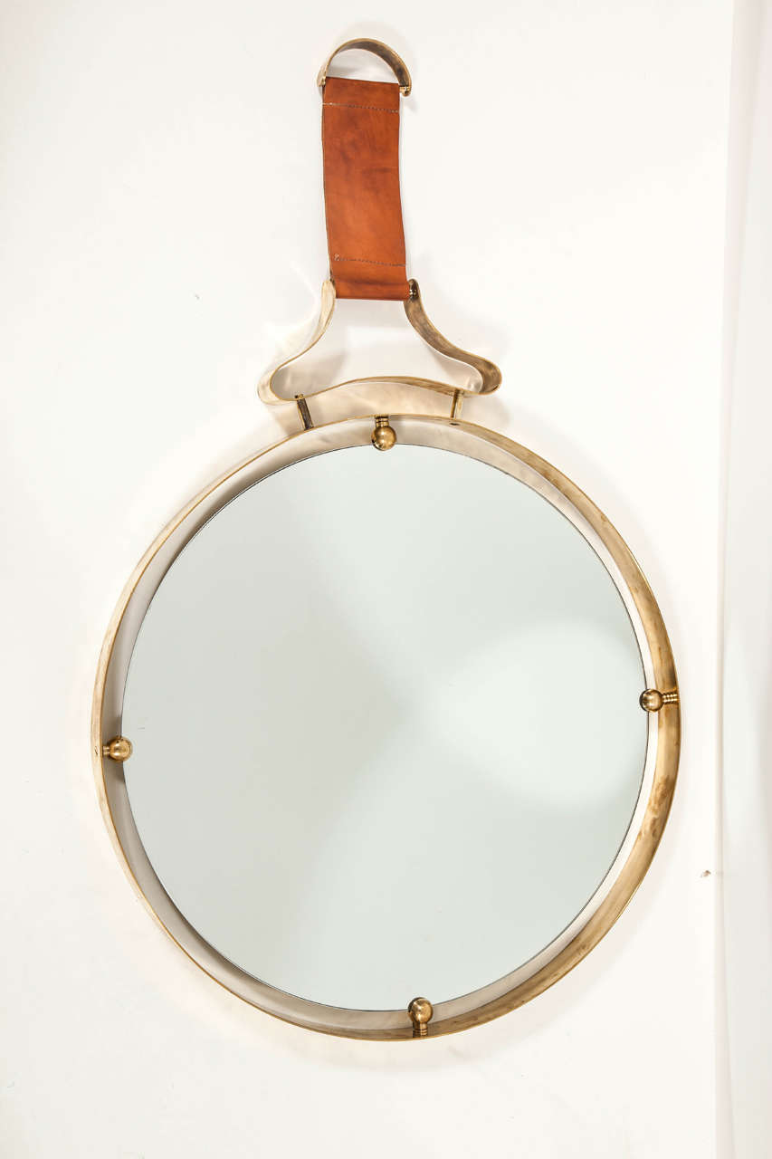 A chic circular brass and stitched leather frame mirror, Italy circa 1970's.
THIS ITEM IS LOCATED IN MANHATTAN AT 1STDIBS@NYDC SHOWROOM. 
200 LEXINGTON AVE - 10TH FLOOR, NYC