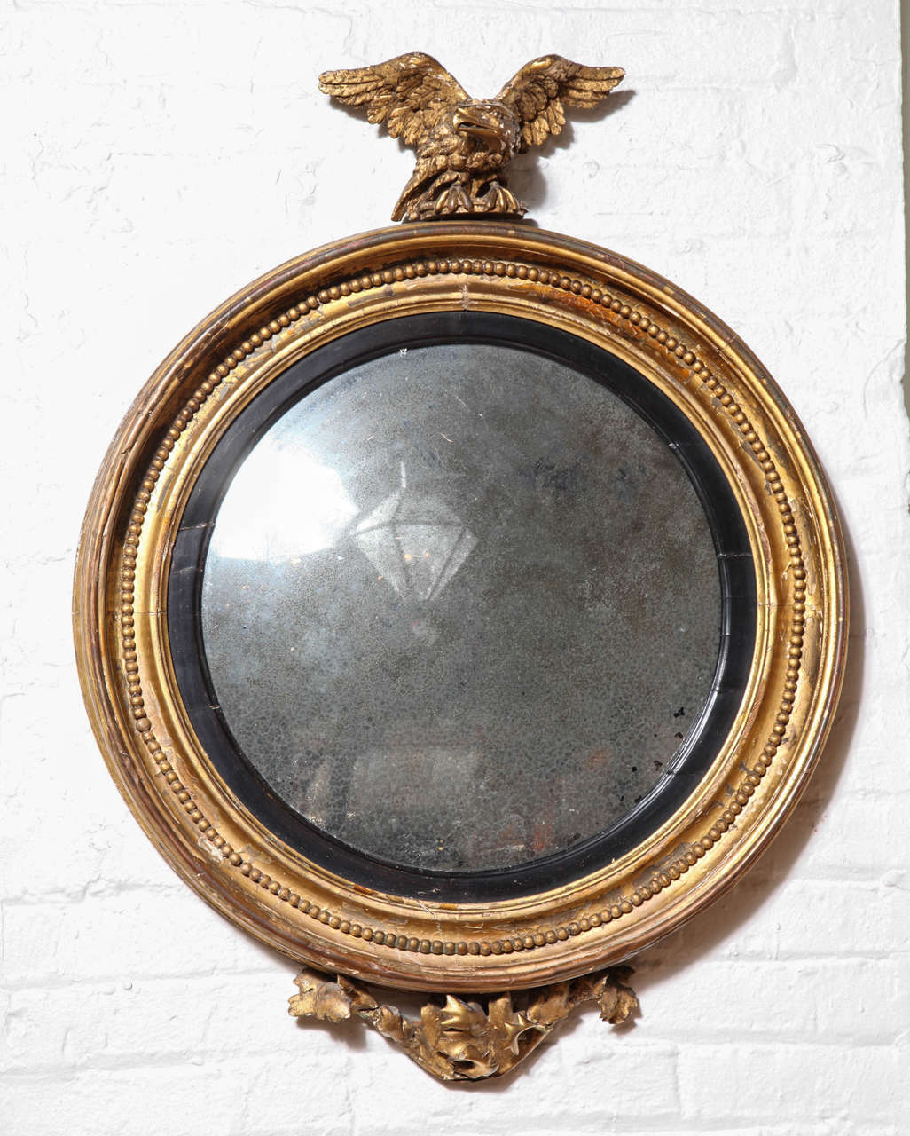 A Carved, Gilded and Ebonized Bullseye/Convex Mirror Surmounted with A Carved Eagle,  England c. 1850