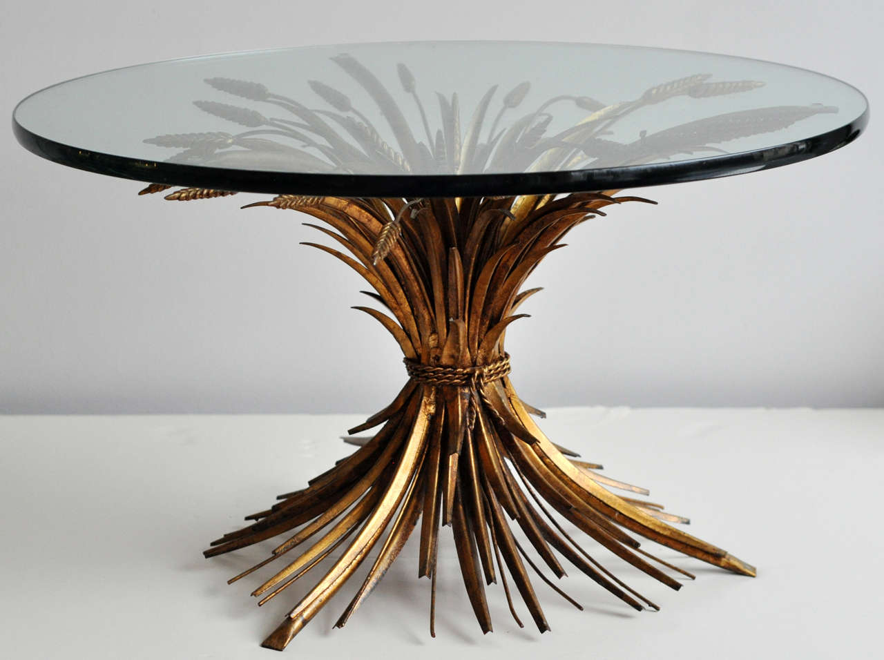 Beautifully-designed and constructed sheaf of wheat table with original gold leaf finish.  It can be used as a coffee or side table. There is the original 