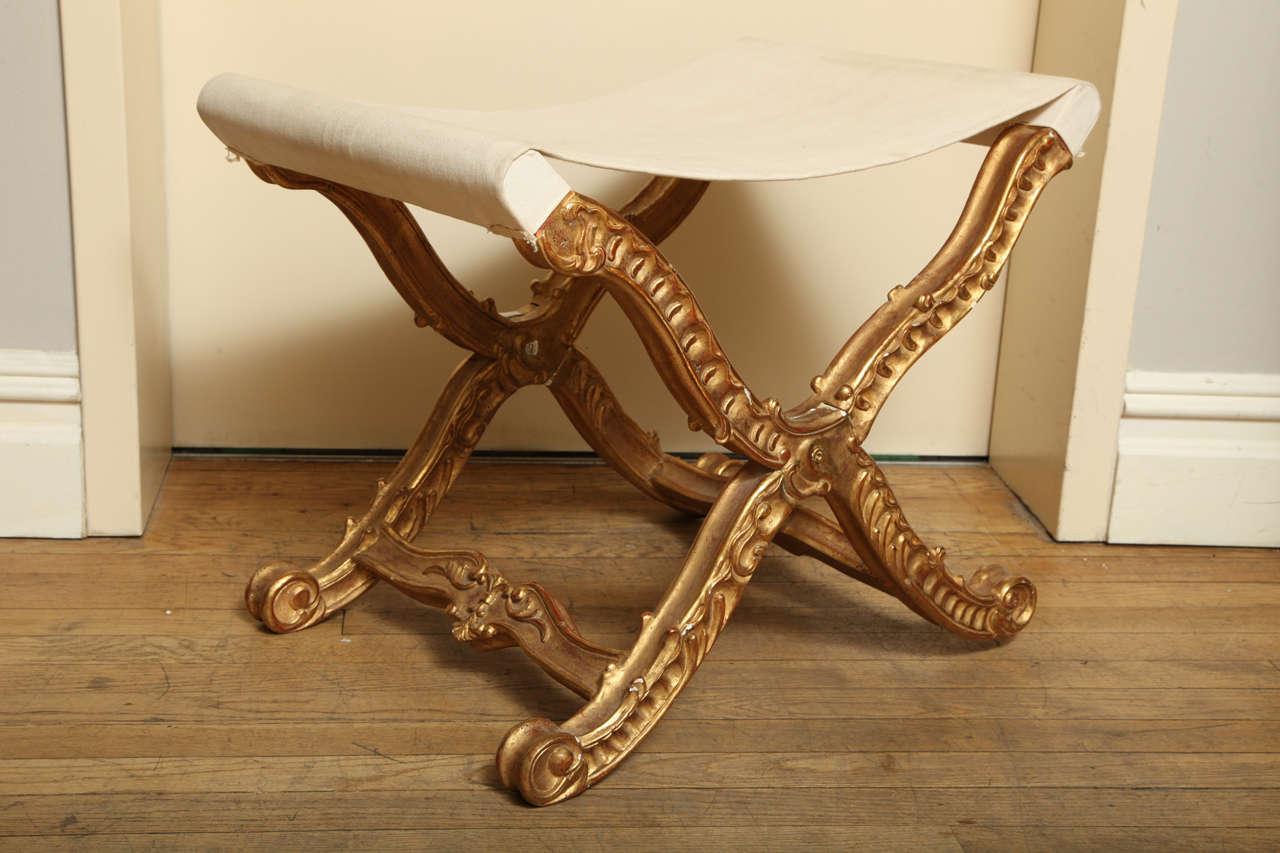A pair of French X-Shaped Louis XV style hand carved pliant stools, the folding frames with frames joined by stretchers. 