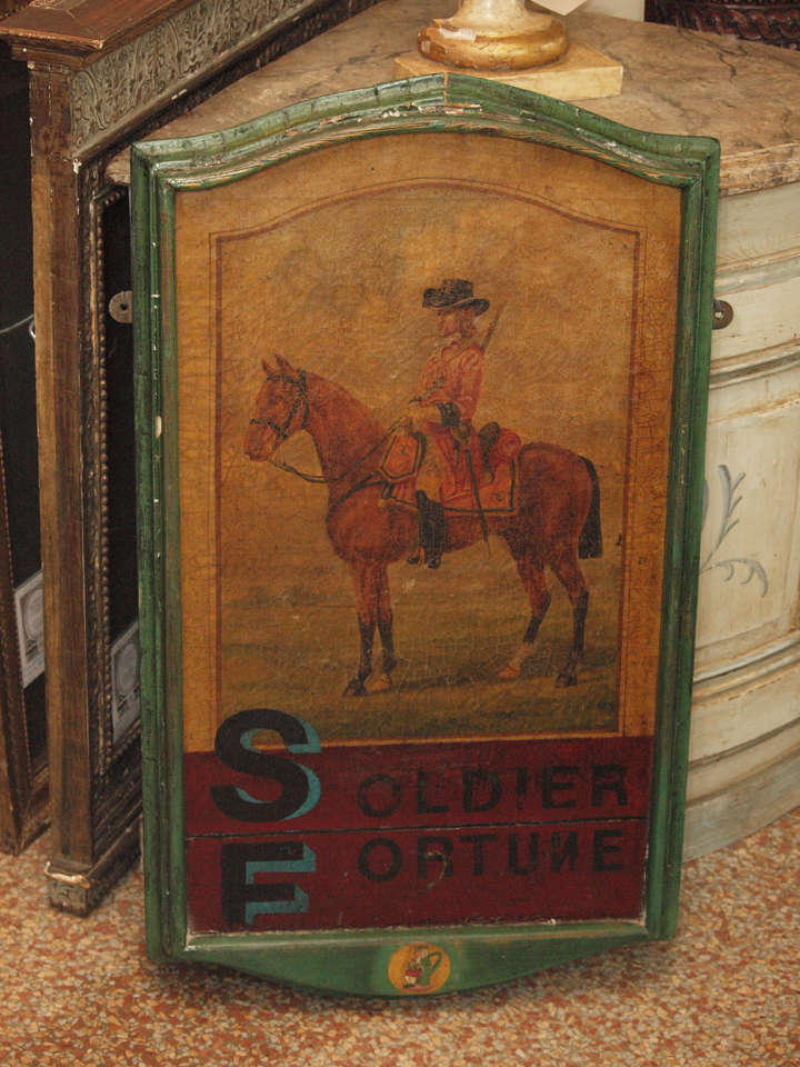 A bright sign painted on board featuring a soldier on horseback with the words 