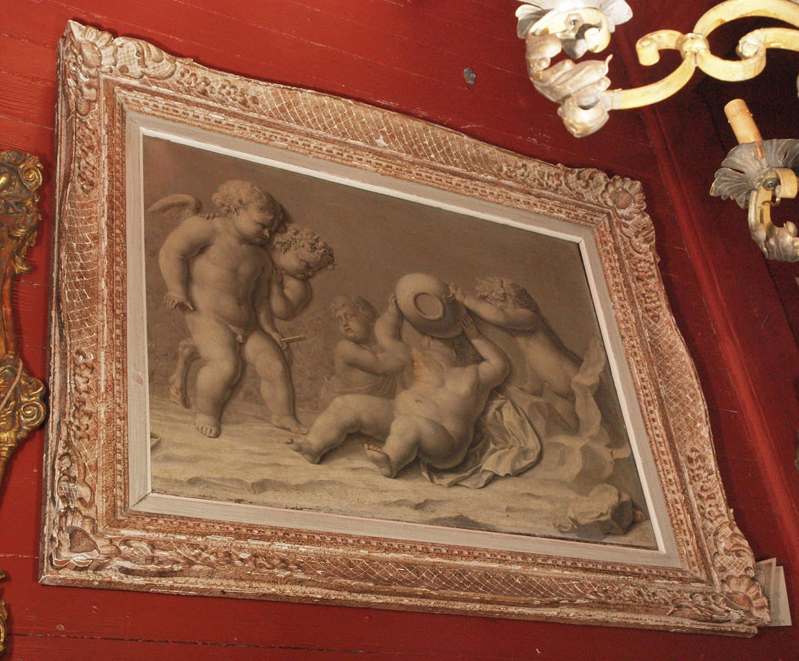 A large grisaille painting of putti and satyrs.  Two of the satyrs head are crowned in a wreath of grape leaves.  The mischievous putti is happily drinking more wine than he should.  Period frame
