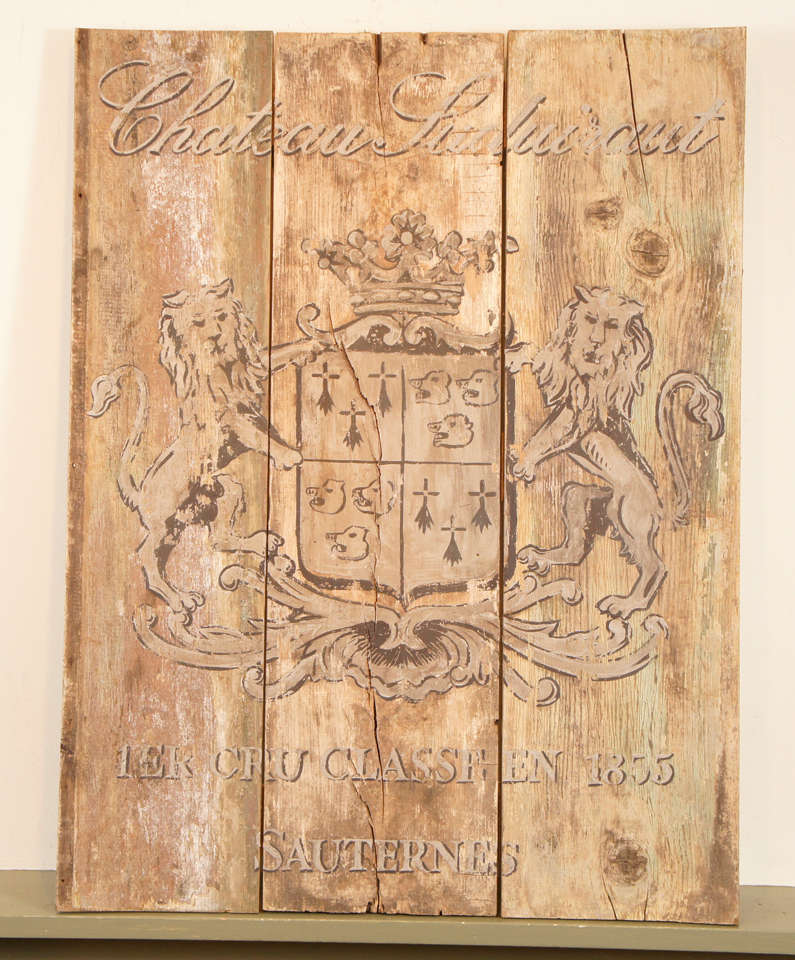 A pair of regal rampant lions hold a crowned sheild on the center of this 1890 French wine sign displaying the Chateau name. Painted on three old boards, the grayish paint is highlighted by hues of black and white. 