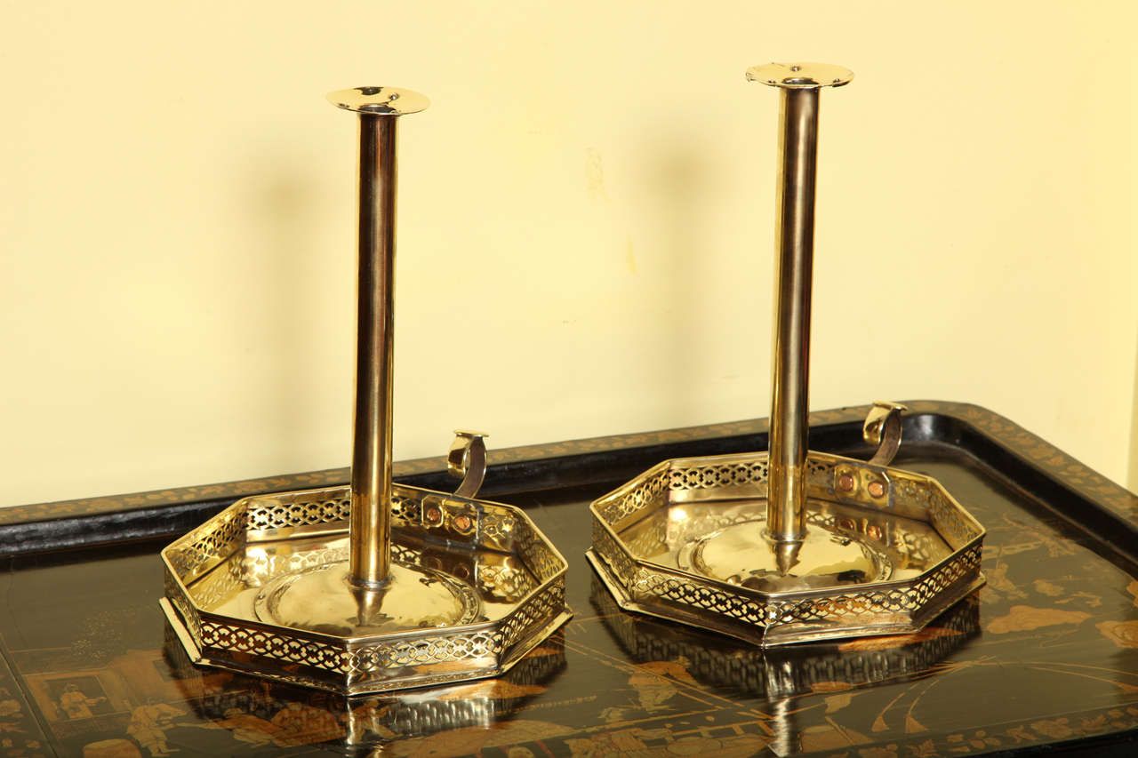 Very Rare Extra Large Pair of Regency Period Brass Chambersticks, each having wide flared nozzles on a columnar stem with domed base, resting on an octagonal plate with finely pierced fret gallery and shaped handle with thumb piece. English c.1800  