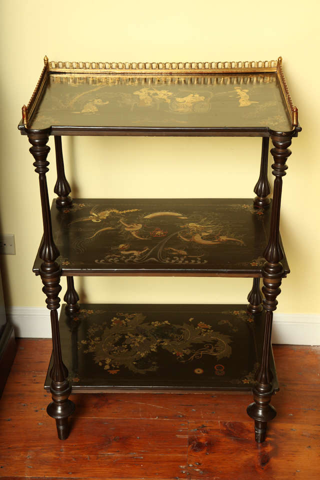 Very fine Chinese export lacquer three-tier etagere surmounted by a pierced giltwood three quarter gallery, the top shelf decorated in polychrome and gilt with ladies in a cart with attendant and guards on horseback, the lower shelves decorated with