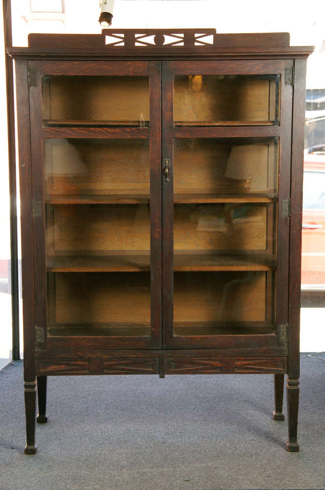 Oak two door bookcase by The Stickley bros. Quaint Furnitre co.
Interior fitted with adjustable shelving. All original hardware and finish. Elegant design with tall Mcmurdow legs and hand hammered copper hardware and lock. 