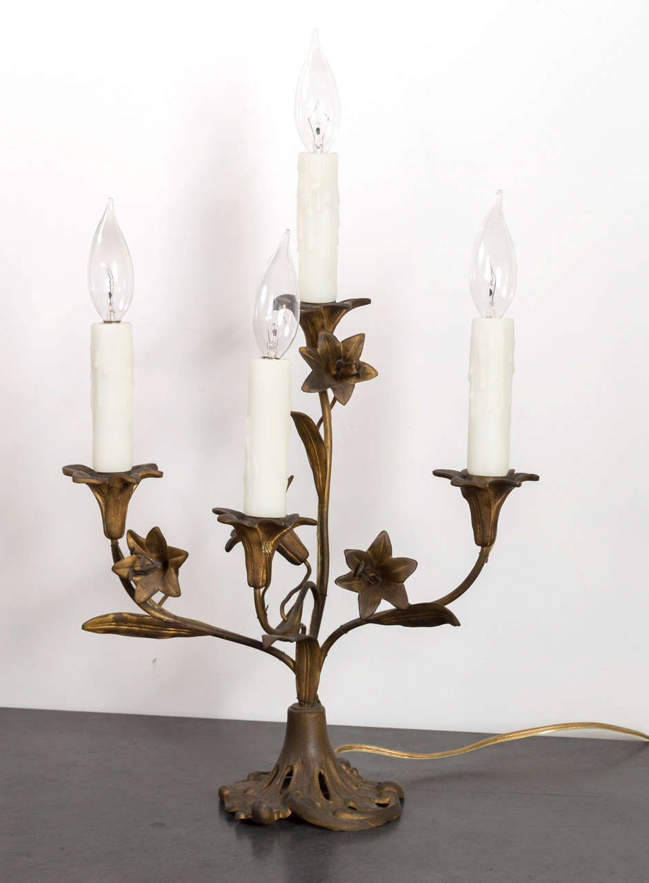 Pair of bronze Art Nouveau lily form four light candelabras.  Ivory resin candle sleeves allow for 60watt max per socket, with or without lamp shade.  Recently rewired.  American, 1920s.