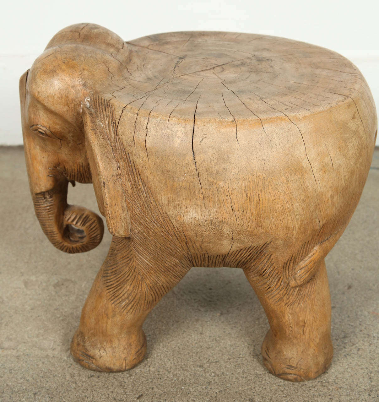 Hand-carved wooden Elephant stool, or occasional table, very nice abstract hand-carved on one piece of wood.
Probably from Thailand