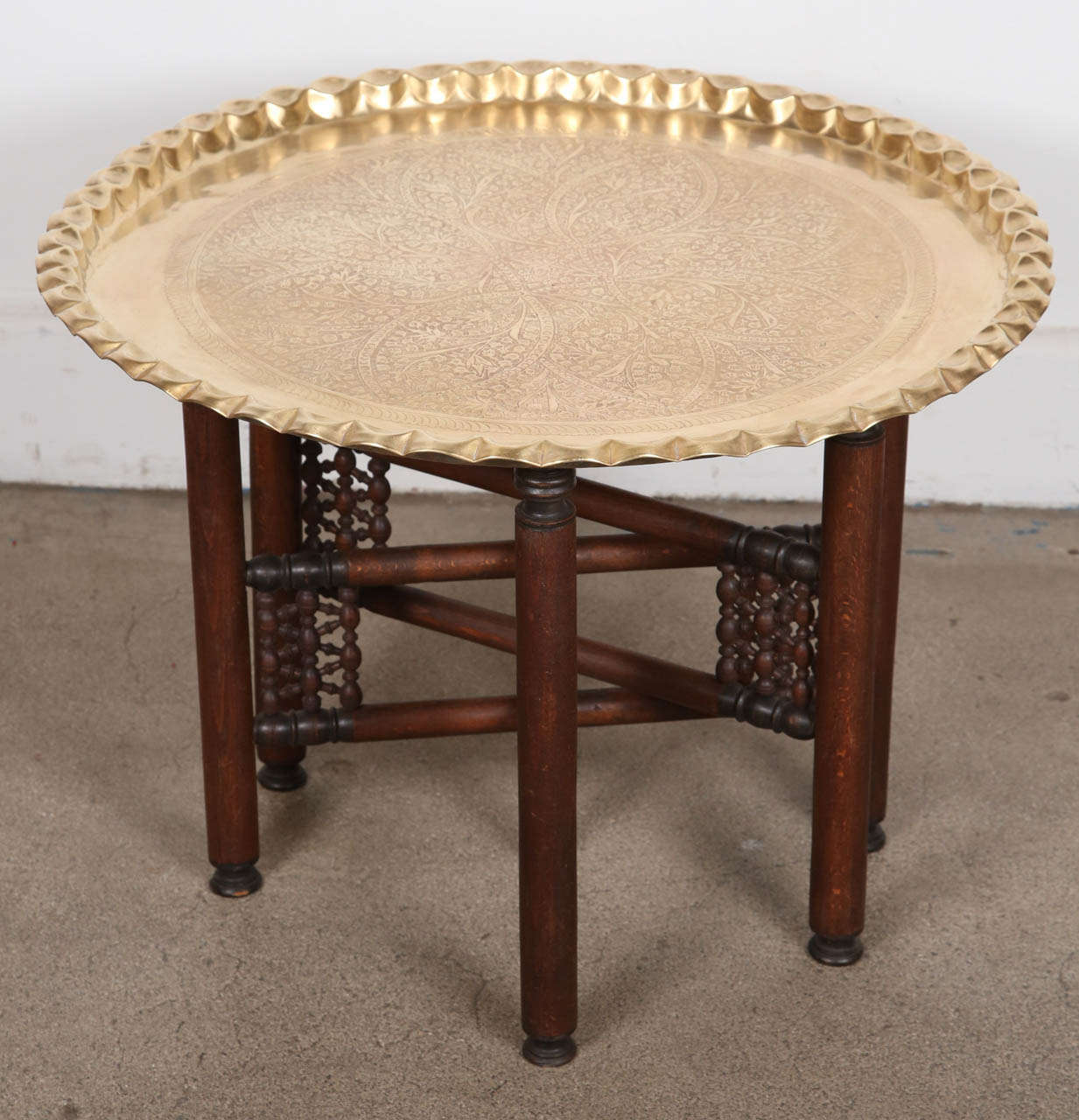 Vintage occasional Moroccan etched brass large round tray table.
Removable etched brass tray table with Moroccan Mahogany six leg base, fold down to flat. Brass top is etched with floral designs and has pie crust edging.
This is a wonderful