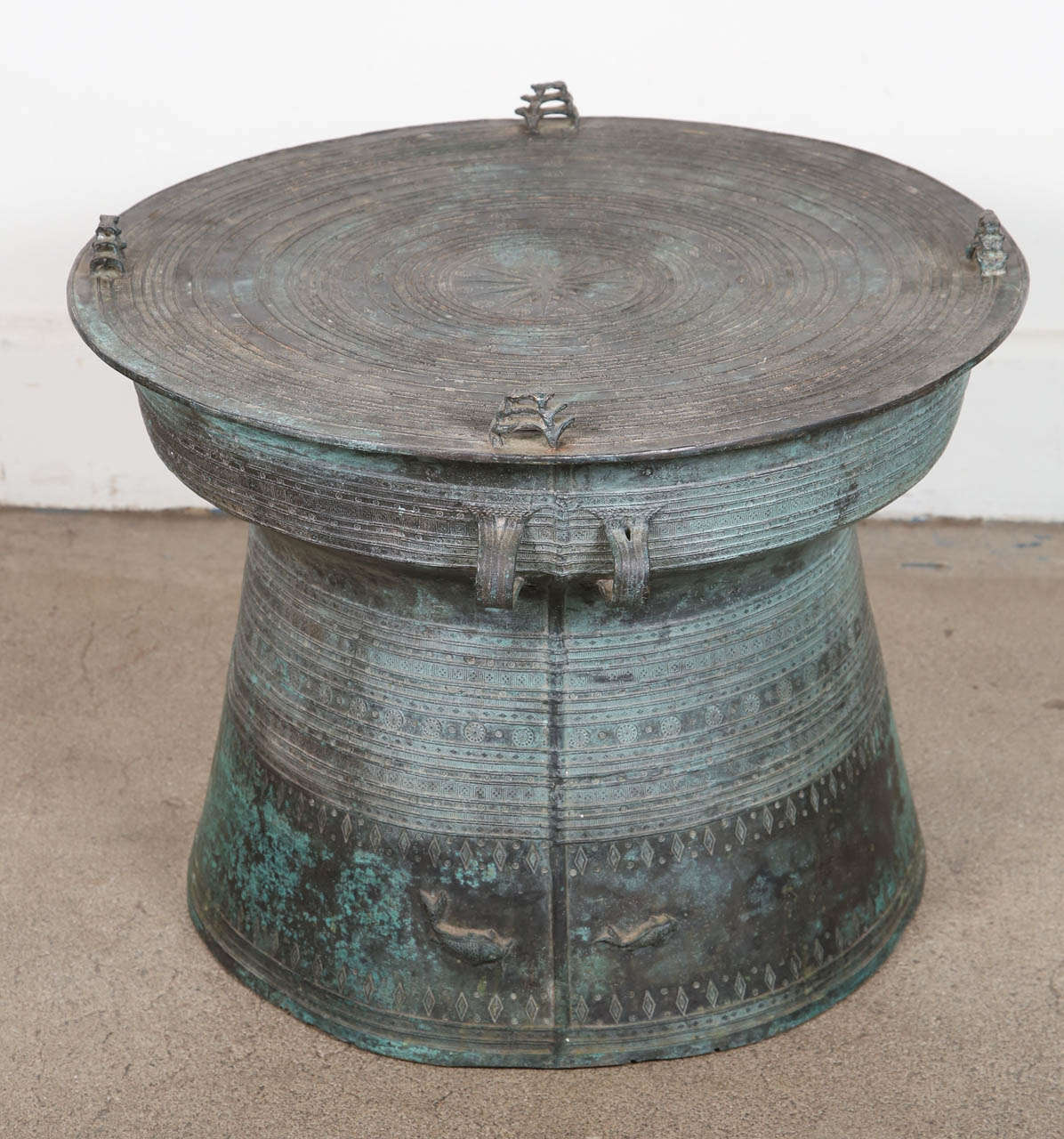 Cast bronze rain drums with the traditional intricate detailing and patterns carved all around both the body and the top. The top is flat centered with a raised star surrounded by concentric geometric patterned bands and with raised triple frog