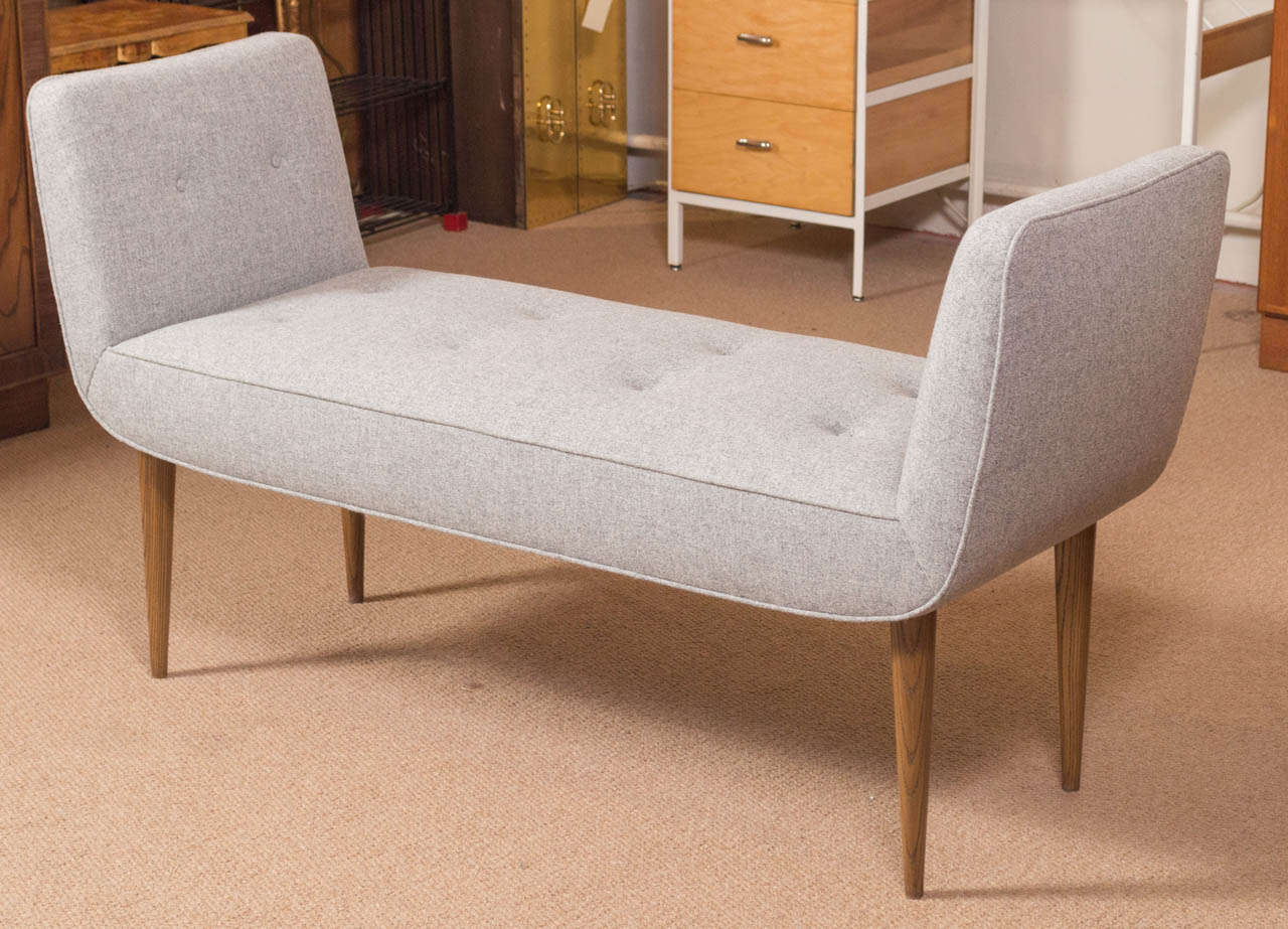 A large and wonderful looking, custom made bench, with flared arms. It's in a light gray wool with Walnut legs. Custom made by a local designer/craftsman.