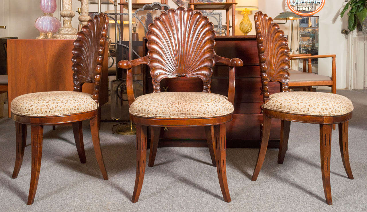 A set of six classic Italian grotto chairs, circa 1940's to 1950's Hand-carved in Walnut, showing their very striking scallop shell backs. Two arm and four side chairs. Presented in lovely restored condition with newly upholstered seats.