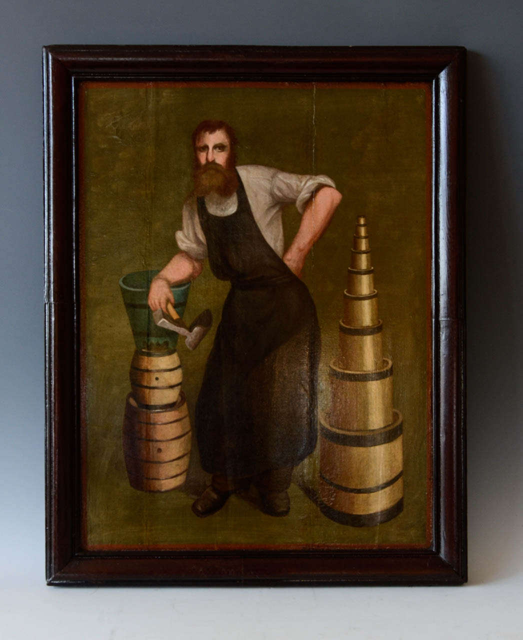 The cooper is represented upright with his apron and holding his adze.
Around him, barrels, bucket and wood measures of all the sizes.