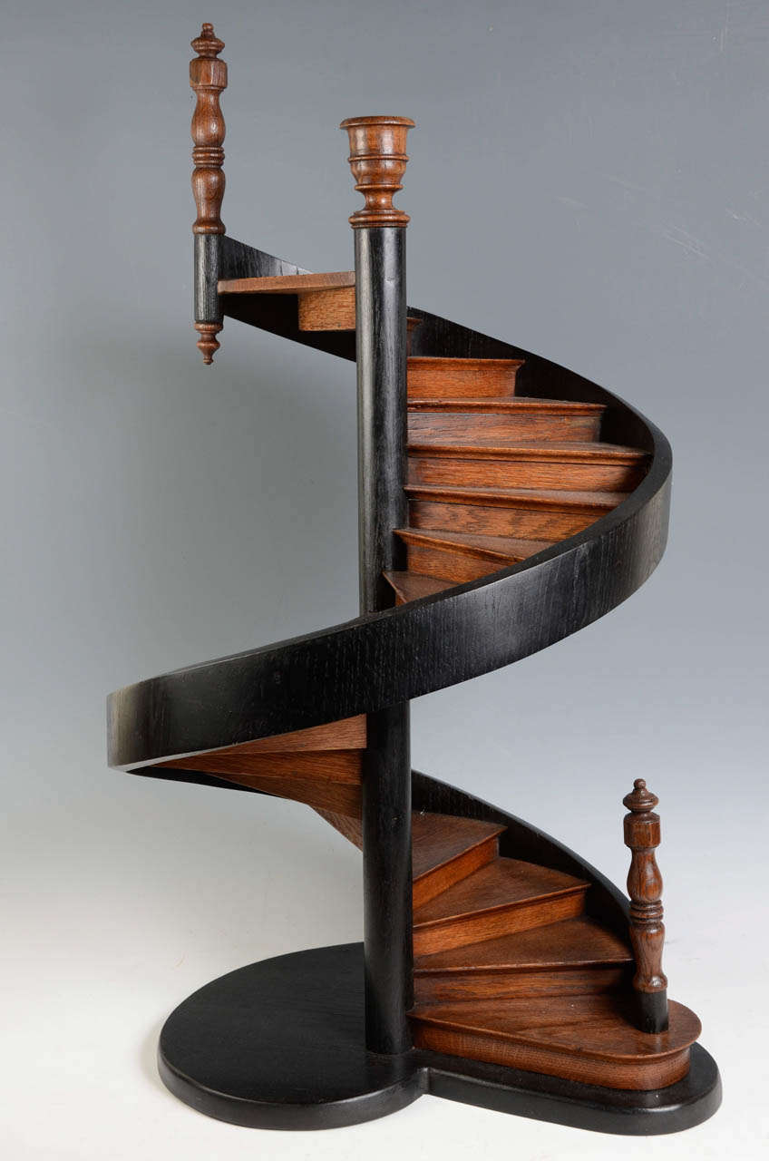 A curved stairway which is mounted on stringers rather than a central pole surmounted by a vase. The staircase step wave is made in an oak tree trunk. Two newels at the bottom and top.