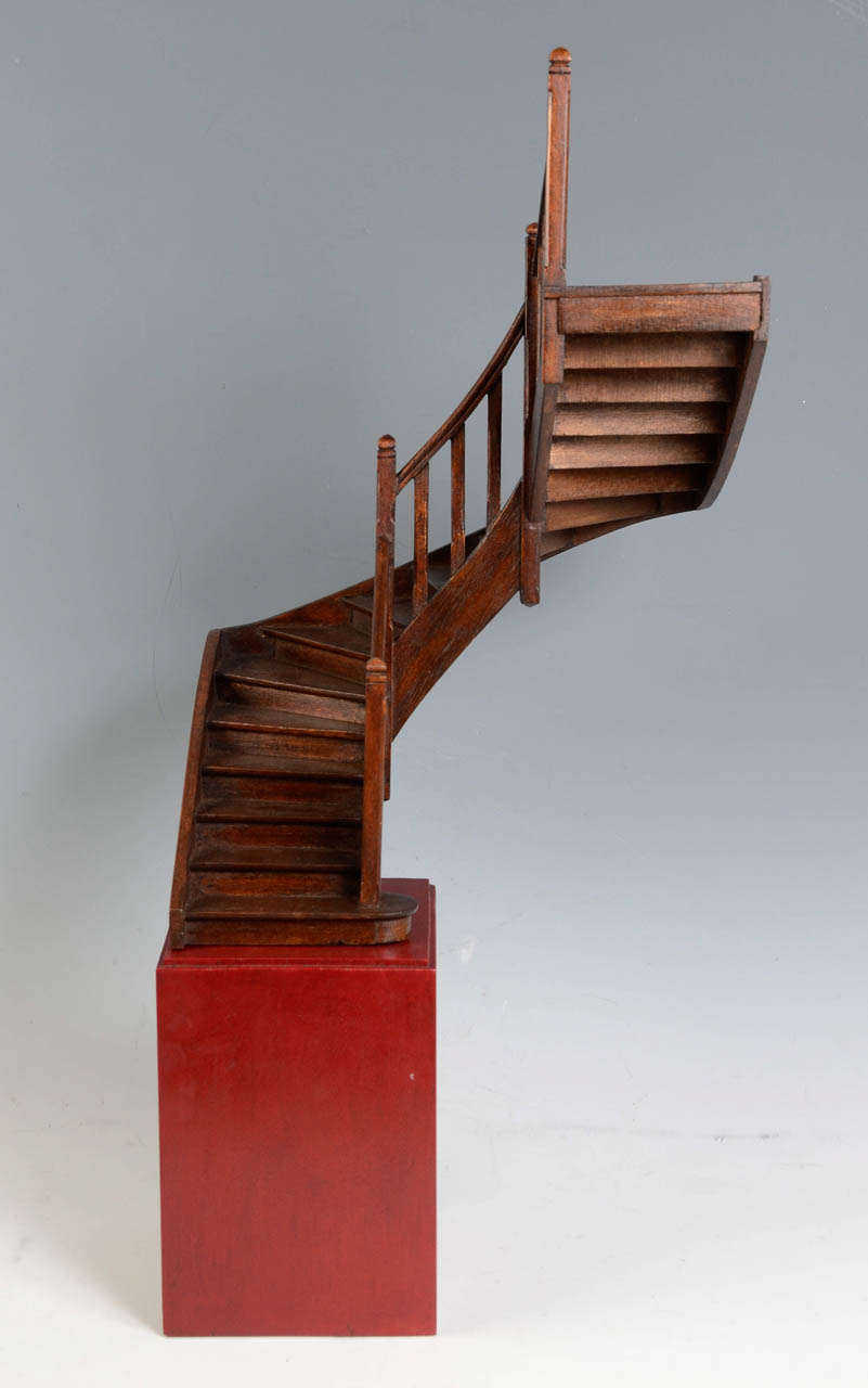 Two quarter revolving masterpiece staircase with one balustrade inside the curve. Carved walnut. Late 19th century.