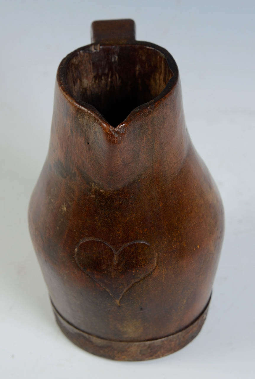 Monoxyle carved wooden pitcher from Provence (east south of France). 
Ring turn with metal banding to base.
Engraved heart as frontal ornement.