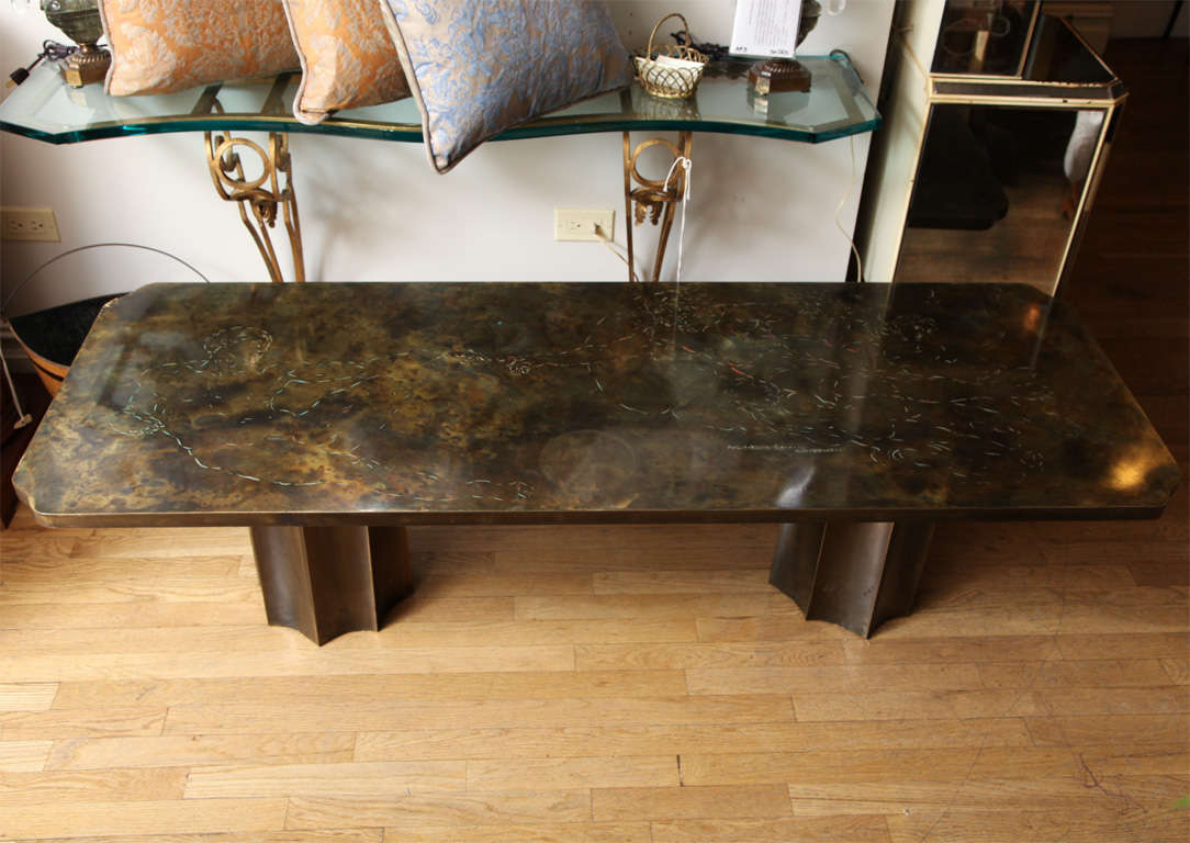 A rectangular brass veneered coffee table by American designers Philip and Kelvin Laverne.  The top with scalloped corners having incised design depicting a detail from Michelangelo's Sistine Chapel.  The top signed Philip and Kelvin Laverne having