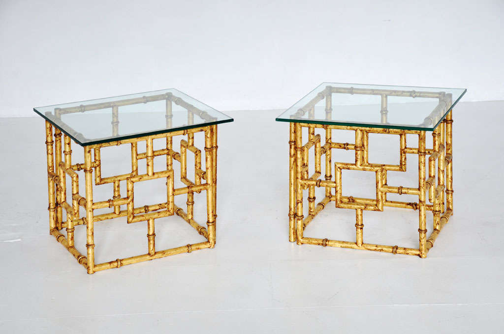 Pair Hoollywood Regency low side tables.  Gold leaf metal fretwork bases with new glass tops.