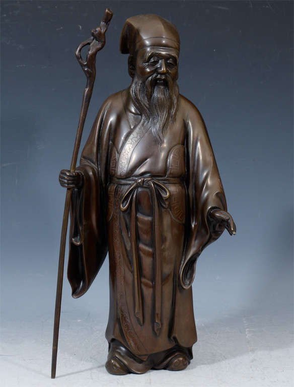 An antique Japanese bronze sculpture depicting an old man with walking staff. The piece dates from the Meiji period (1868-1912).

4608