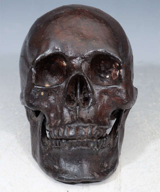A vintage metal sculptural replica of a human skull. The cranium rests upon the separately cast mandible. There is a long tradition of the memento mori (latin 