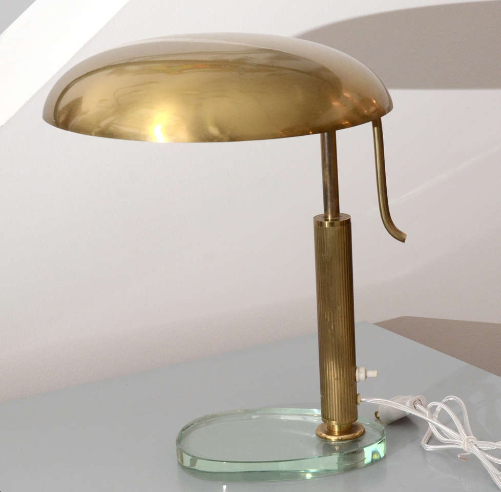 Italian Table Lamp by Stilnovo. An adjustable Round Brass Shade,Connected to a Brass Stem and Glass Base