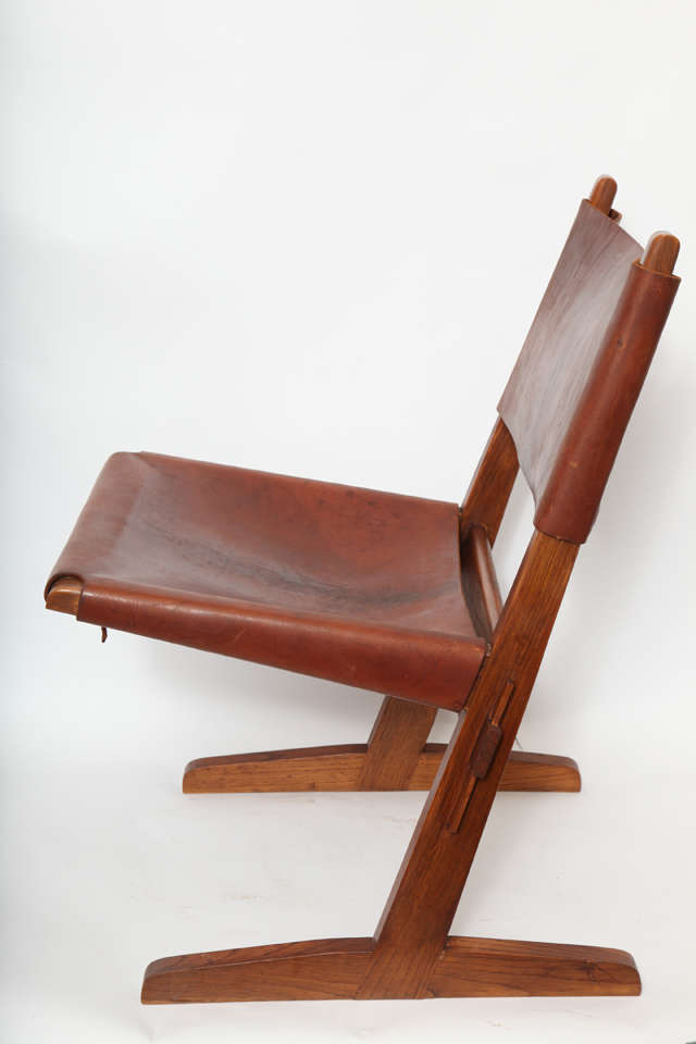 A 1950s American modernist wood and leather architectural chair.
