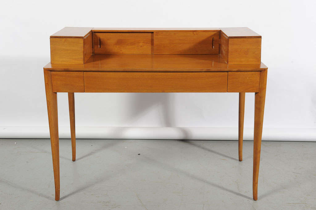 T.H. Robsjohn-Gibbings desk, by Widdicomb, bleached walnut, upper gallery with hinged compartment at left and right and two sliding doors, one drawer below writing surface, slight flare to legs at tips, original finish, 46