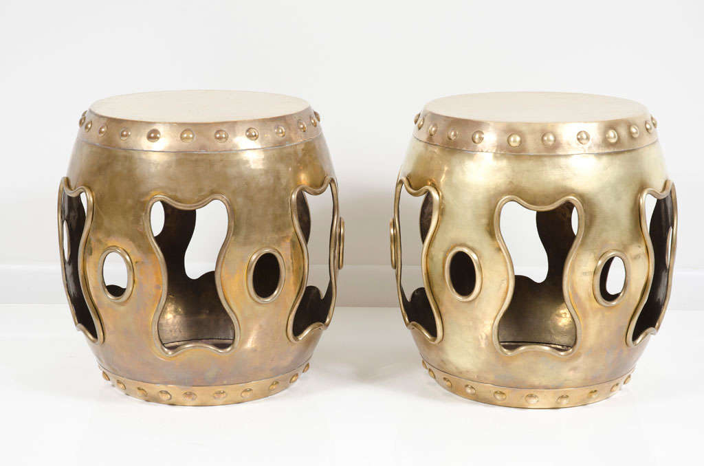 A pair of garden tables or end tables in a traditional Chinese drum tabouret form, both in polished brass with a round bulbous form and pronounced rivet head construction to top and bottom. Chinese, circa 1970.