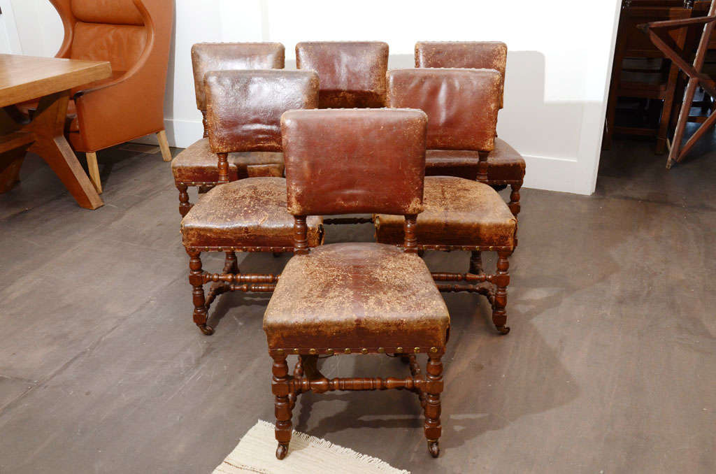 Set of six Antique leather chairs, England, 19th century. 

These classic dining chair consist of a turned wooden frames, original leather with a beautiful rustic patina, and brass nail heads. All chairs sit on casters. 

Great antique