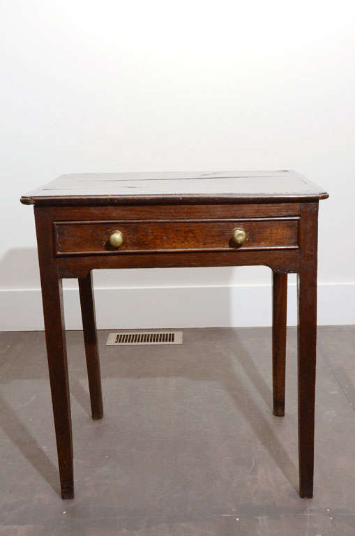 19th century George III oak side table with handsome brass knobs and a rustic plank top.

This table is in very good antique condition.