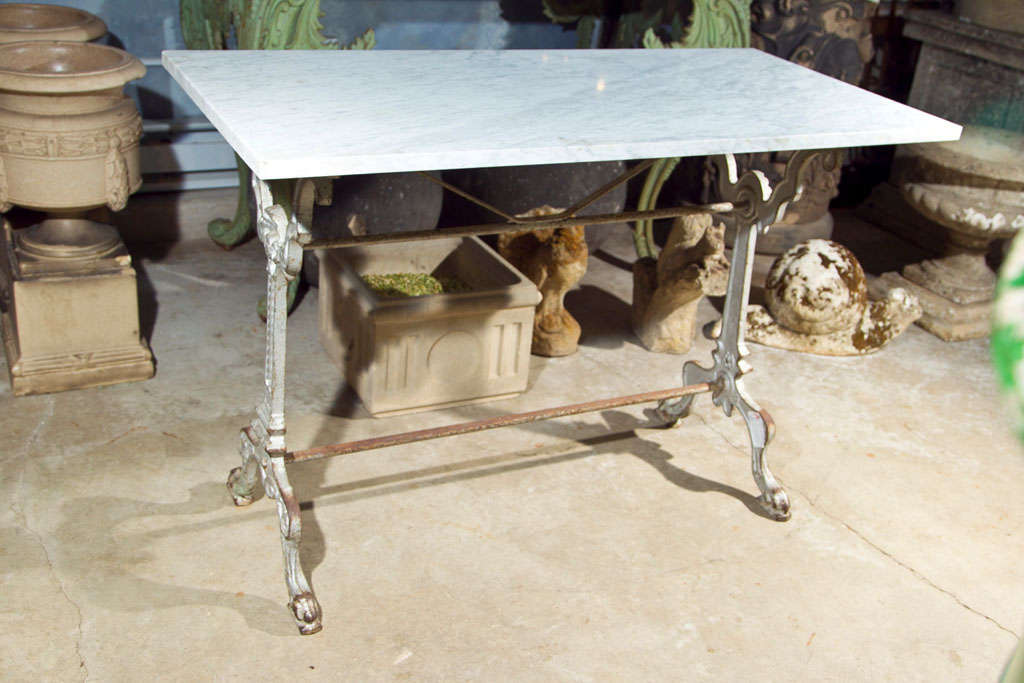 This beautiful cast iron conservatory table has shell and scroll decorations on the legs, paw feet and a wonderful old silver painted patina.  An antique, but probably not original, rectangular piece of white cararra marble with grey streaks
