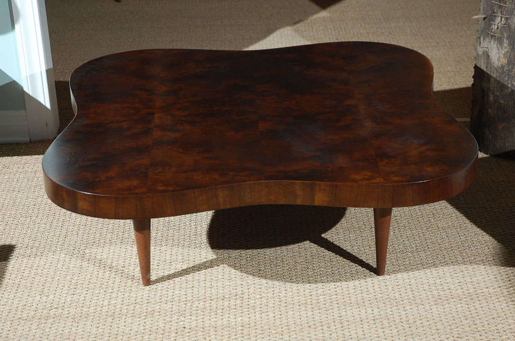 Sophisticated large mid century cocktail table by legendary American designer with leather wrapped legs. Burl walnut top. Top refinished.