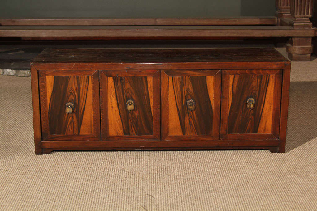 Small Korean document chest with four drop front panels made of persimmon wood; the panels fitted with leaf form brass pulls. The second panel from the right lifts out and the rest slide revealing an open space within and a four small drawers