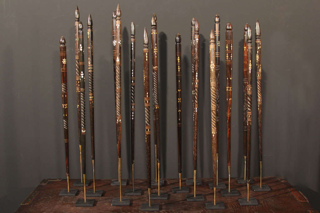 A collection of ninteen carved and turned wood teacher's pointers. Constructed of kamagong (false ebony), the tapering wands with mother of pearl inlay and incised decoration. Mounted individually on custom metal stands.<br />
Luzon Islands,