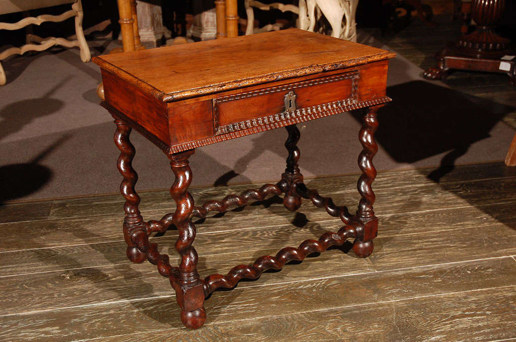 A beautiful side table with bevel carved drawers and molding above a barley twist leg and box stretcher on ball feet