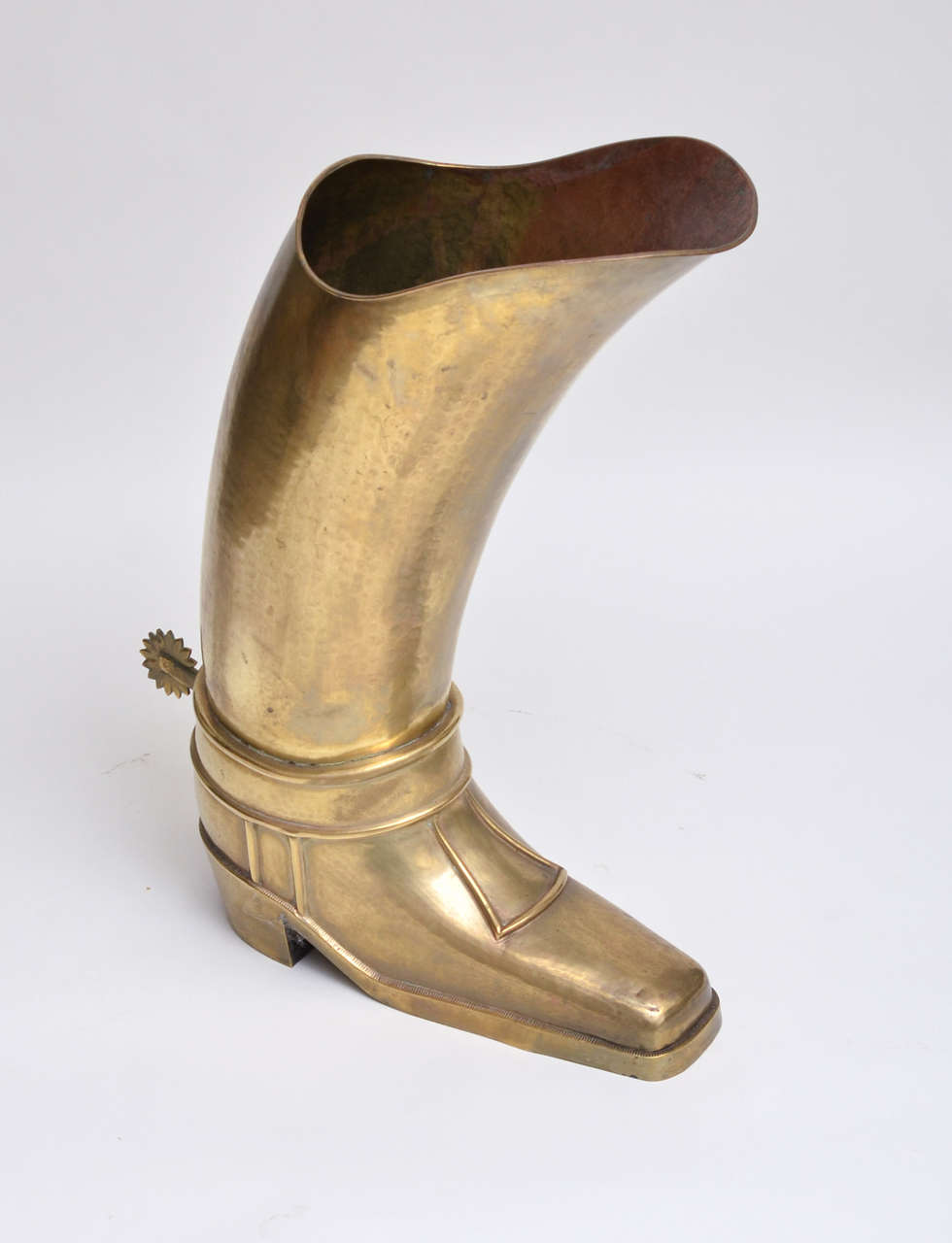 Hammered brass umbrella stand in the form of a cowboy boot.