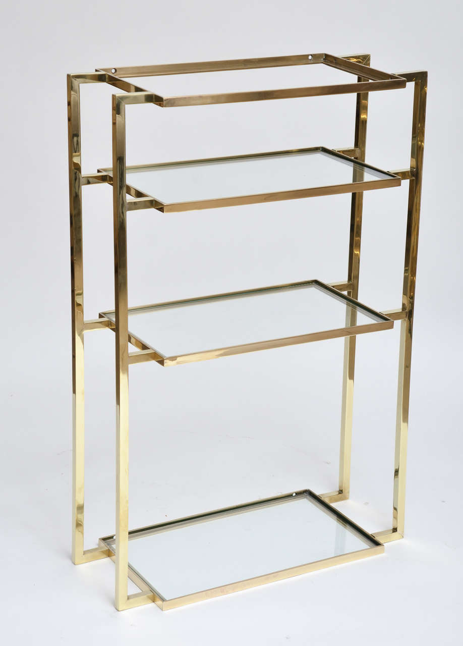 Wall-mounted four shelf brass vanity.
