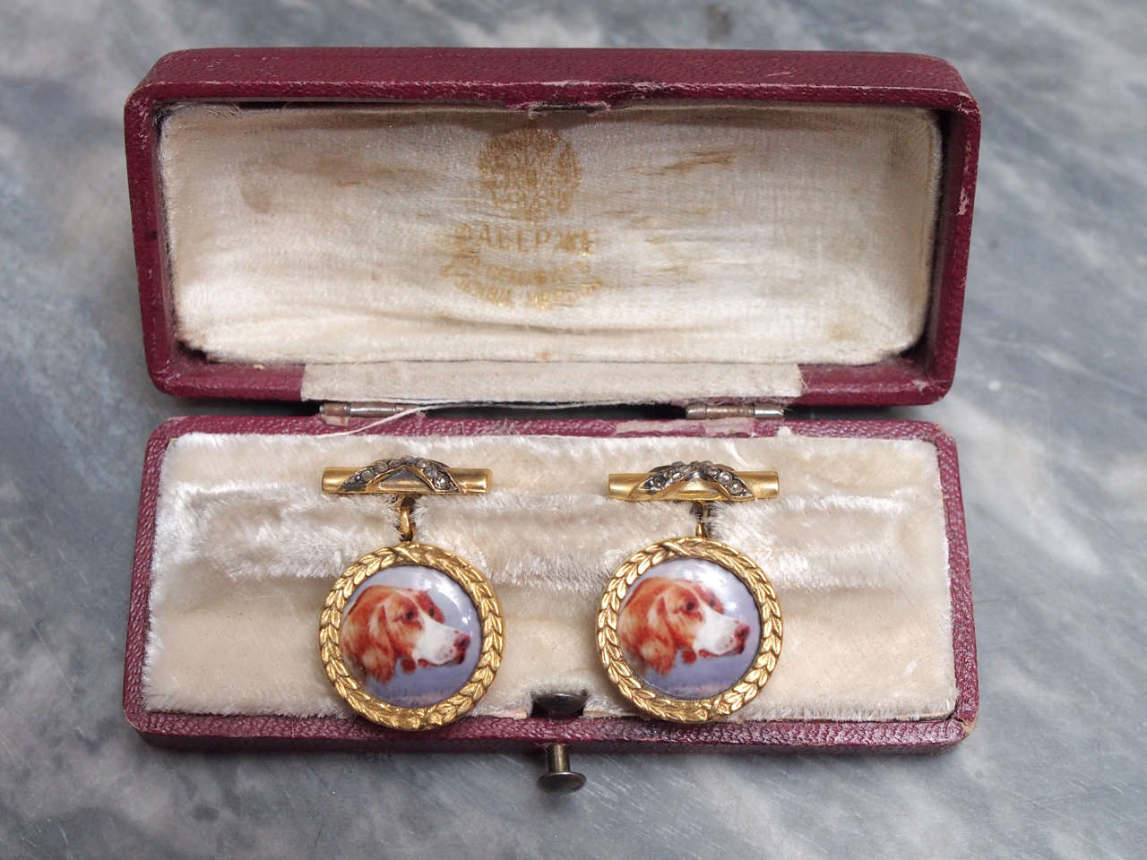 Pair of antique Russian cufflinks with miniature portraits of hounds framed by laurel wreaths and X ribbons of diamonds on the rear. In original case.