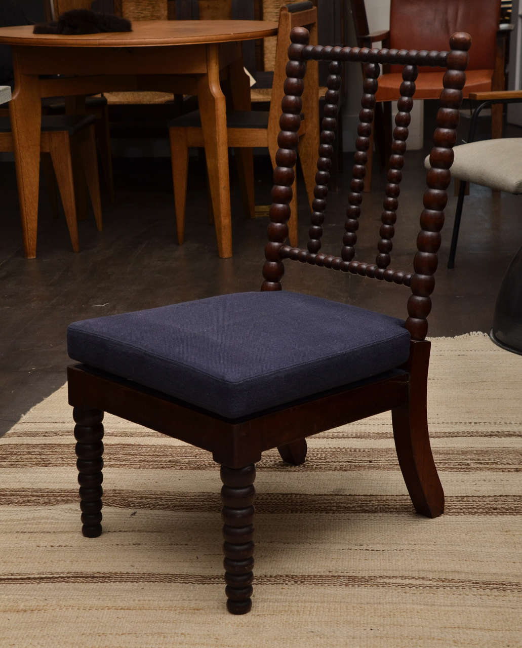 Bobbin style side chair with three-spindle backrest. Newly upholstered navy linen seat cushion.