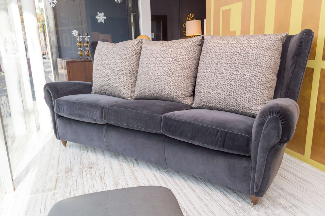 Bold and luxurious style in this Italian Mid-Century Modern wingback sofa.
Upholstered in charcoal mohair with black leather piping and Fortuny fabric back cushions.
Extremely comfortable, a must see to appreciate.