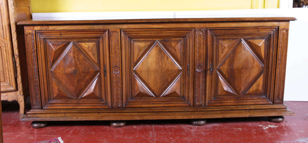 18th Century Louis XIII Walnut Buffet/Enfilade reposing on bone feet. Rich and deep patina, this buffet features 3 drawers inside. The front doors and both side panels are carved with 