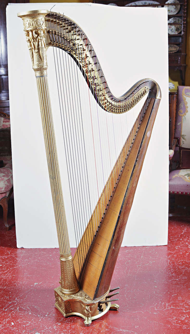 This beautiful, antique Sébastian Érard double action concert harp was created in France and dated 1811. With seven pedals, impressive gilding and thoughtful burr and maple wood marquetry, the music instrument makes a statement of elegance. The