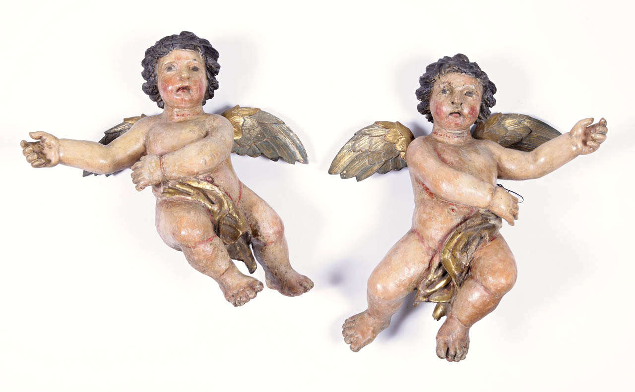 These large winged cherub figures were hand carved in Italy, circa 1720. The hand-painted putti carvings feature their original polychrome and gold leaf finish for a luxurious result. The cherubs are expressive in their movement and facial