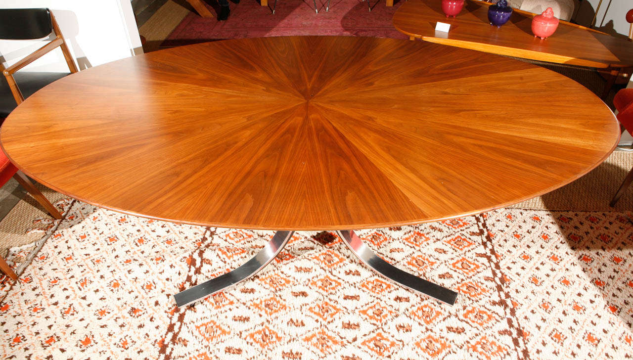 An elegant elliptical table suited to the dining room as well as the conference room, the stainless steel base is polished with black metal details. Designed in the 1960s, the walnut veneer top features a sophisticated starburst pattern. Truly